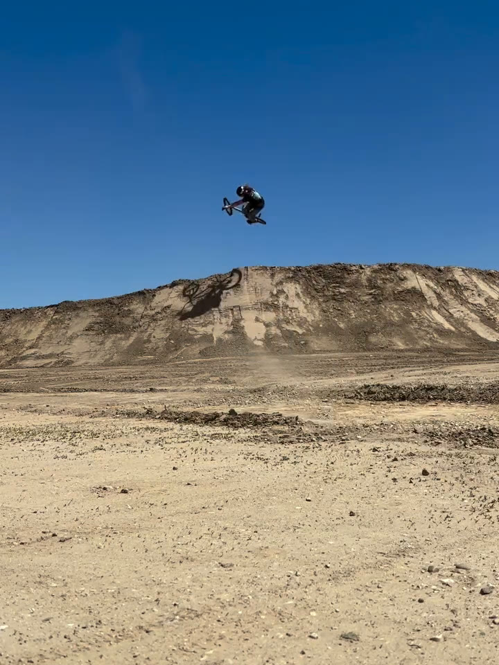 Melville Smith whipping the bike sideways high above a dirt quarter