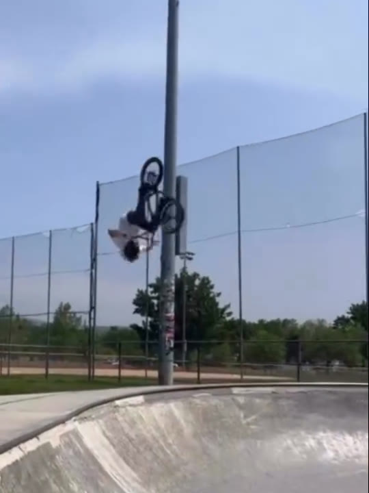 Melville Smith upside down mid-air beside the light pole above the bowl
