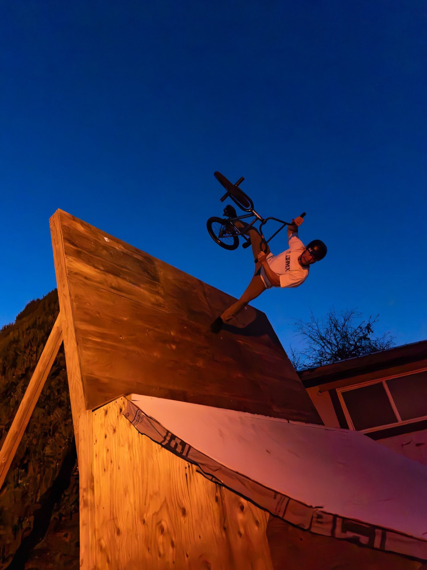 Melville Smith tapping the top of the wall ramp, bike vertical against the sky